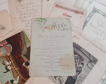 Puede incluir: Una tarjeta de menú vintage con un diseño floral y el texto "MENU" en una fuente decorativa. El menú enumera una cena del 24 de mayo de 1898, con platos franceses como Jambon Braisé, Filet de Boeuf y Fonds d'Artichauts à l'Anglaise.