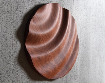 large solid wood round sculpture with irregular waves