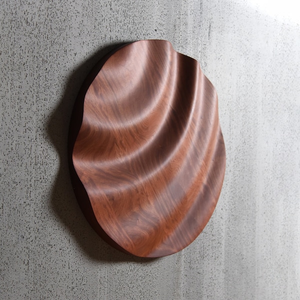 large solid wood round sculpture with irregular waves