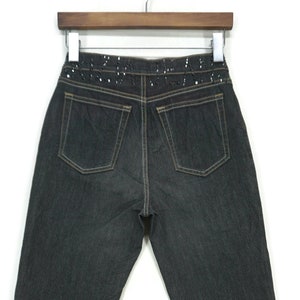 May include: Dark wash denim jeans with a black sequined waistband.