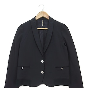 May include: A black blazer with a notched collar, three silver buttons, and two flap pockets. The blazer has a scalloped hem and the label "FRAPBOIS" is visible on the inside.