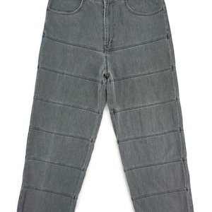 Op de afbeelding: Grijze denim jeans met horizontaal gestikte panelen. De jeans heeft een knoop- en ritssluiting, voorzakken en riemlussen. De jeans heeft een medium wassing en een rechte pijp.
