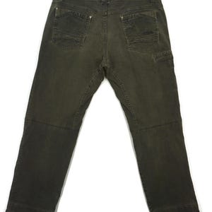 Puede incluir: Un pantal&oacute;n cargo de color verde oscuro con m&uacute;ltiples bolsillos y corte recto.