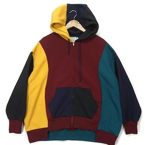 May include: A multi-colored zip-up hoodie with a black, yellow, red, and teal color scheme. The hoodie has a kangaroo pocket and a drawstring hood.