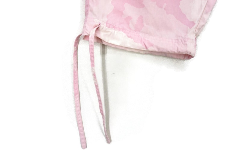 May include: Close-up of the bottom of pink camouflage pants with a drawstring.