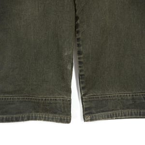 Puede incluir: Un par de pantalones vaqueros de color verde oscuro con pierna recta y dobladillo.