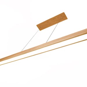 Könnte beinhalten: Eine moderne, rechteckige Holz-Pendelleuchte. Die Leuchte hat eine natürliche Holzoberfläche und eine helle, lineare LED-Lichtquelle. Sie wird mit dünnen Metallkabeln und einer rechteckigen Holzmontageplatte von der Decke abgehängt.