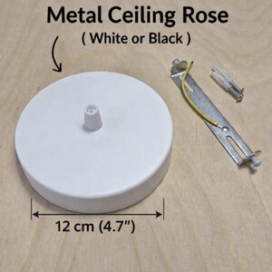 May include: A white metal ceiling rose, 4.7 inches in diameter, with a central fitting. Includes a mounting bracket, screws, and wiring. Text on the image reads "Metal Ceiling Rose (White or Black)".