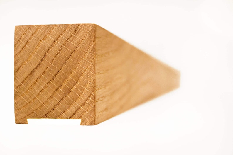 May include: Close-up of a section of a light brown wooden beam. The end of the beam is square with a notch cut out of the bottom. The wood grain is visible, showing the natural texture and pattern of the wood.