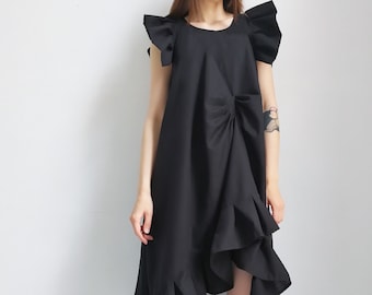 May include: A black dress with a ruffled hem and a gathered detail at the waist. The dress has short, ruffled sleeves.