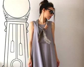 May include: A woman wearing a gray sleeveless dress with a long, multi-colored feather necklace and pink sneakers.
