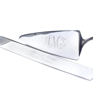 May include: Silver cake knife and server set with engraved monograms and the text "Allison & Thomas October 19, 2019".