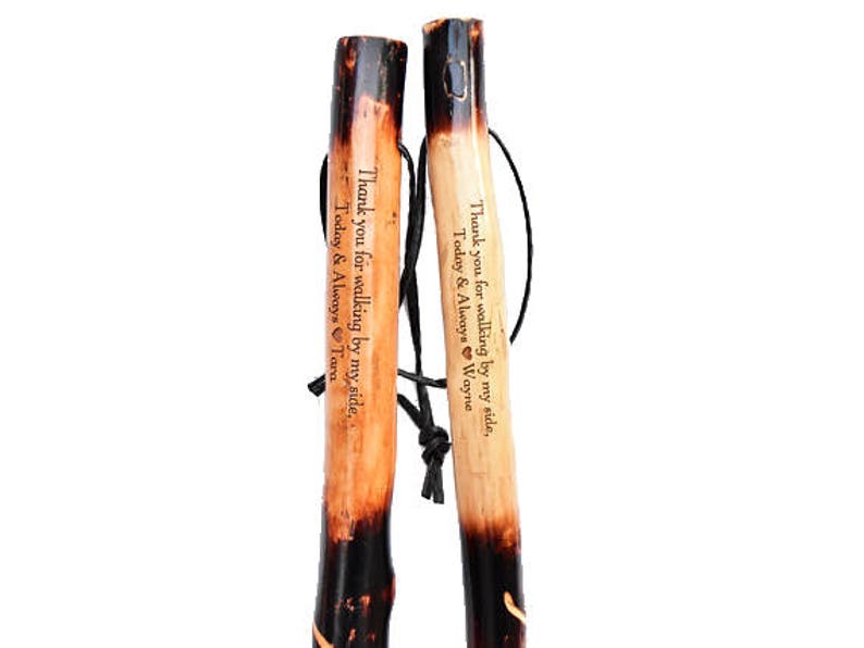 Pu&ograve; includere: Due bastoni da passeggio in legno con punte nere e messaggi incisi. I messaggi recitano "Grazie per aver camminato al mio fianco, Oggi e per sempre Wayne" e "Grazie per aver camminato al mio fianco, Oggi e per sempre Tara".