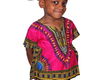 Puede incluir: Un conjunto de top estilo dashiki y pantalones cortos de color rosa brillante con un vibrante patrón geométrico y floral multicolor en amarillo, azul, negro y blanco. El top tiene mangas cortas, cuello en V y cintura ceñida fruncida.