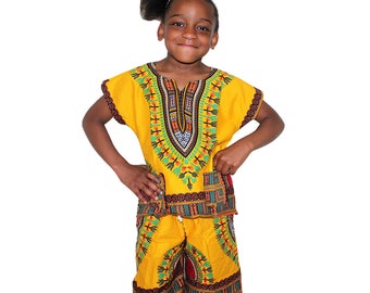 Puede incluir: Un conjunto de camisa y pantalones cortos dashiki con estampado amarillo y negro para niños. La camisa tiene cuello en V y mangas cortas. Los pantalones cortos tienen cintura elástica.