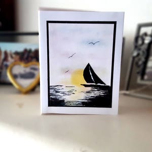 Cartão pintado à mão com um lindo barco à vela e pôr do sol