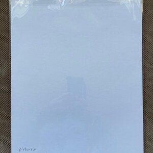 May include: A white sheet of paper with the text "P774-810" written in black ink at the bottom.