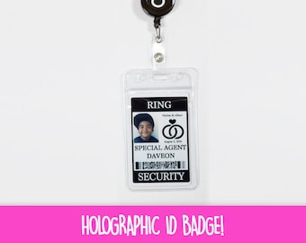 May include: Clear plastic ID badge with a black and white ring design on a retractable reel. The badge displays a photo, the word "RING", and the text "SPECIAL AGENT DAVEON". The bottom of the badge reads "SECURITY".