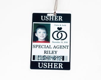May include: Black and white wedding usher badge with a photo of a young boy, the text "USHER", "SPECIAL AGENT RILEY", "Pattie & Andy", "December 31, 2016", and a barcode.