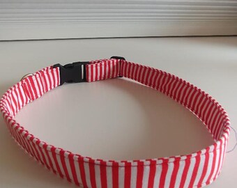 Puede incluir: Collar de perro a rayas rojas y blancas con una hebilla de plástico negra.