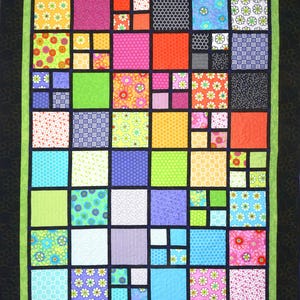 May include: A colorful patchwork quilt with a black border and a green inner border. The quilt features a variety of square blocks in vibrant colors and patterns, including floral, polka dot, and striped designs. The quilt is a mix of bright and cheerful colors.
