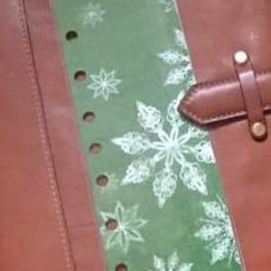 May include: Clear plastic planner page marker with a snowflake design on a green background. The marker has six holes for use in a disc bound planner.