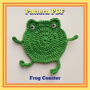 May include: Green crocheted frog coaster with googly eyes. The text "Pattern PDF" and "Frog Coaster" are written below the frog.