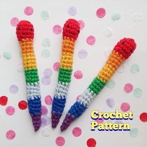 May include: Three handmade crochet pencils in rainbow colors: red, orange, yellow, green, blue, and purple. Each pencil has a smiling red face and is set against a background of colorful confetti. The text "Crochet Pattern" is visible.