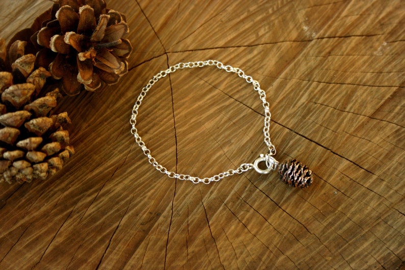 Handmade sterling silver chain bracelet with pink bronze pinecone charm. Each charm is crafted from a cast of an actual miniature cone. By Curious Magpie Jewellery.