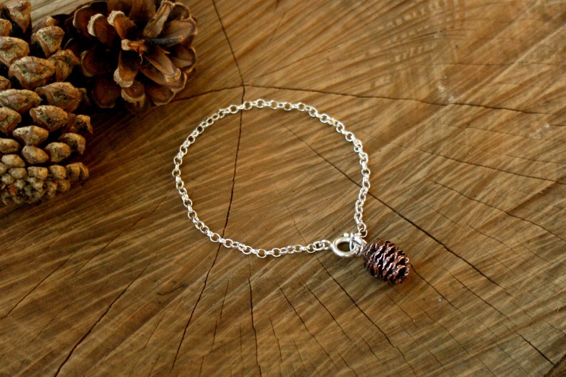 Handmade sterling silver chain bracelet with pink bronze pinecone charm. Each charm is crafted from a cast of an actual miniature cone. By Curious Magpie Jewellery.