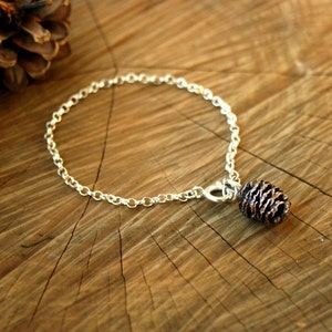 Handmade sterling silver chain bracelet with pink bronze pinecone charm. Each charm is crafted from a cast of an actual miniature cone. By Curious Magpie Jewellery.