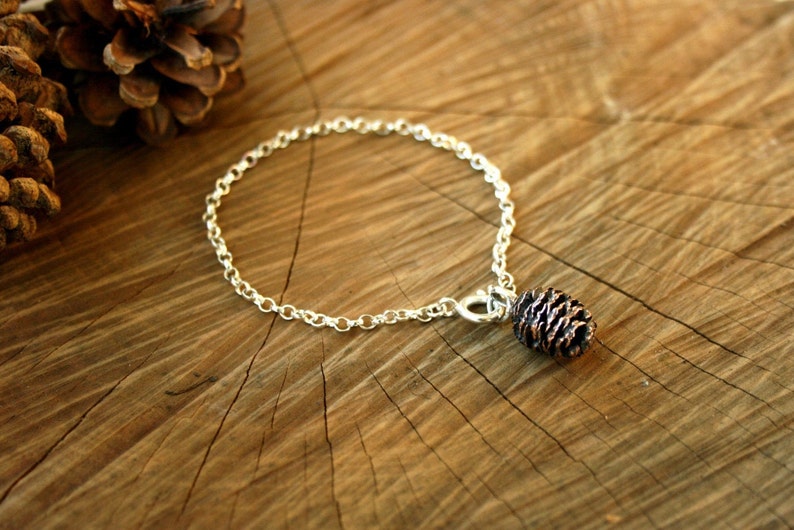 Handmade sterling silver chain bracelet with pink bronze pinecone charm. Each charm is crafted from a cast of an actual miniature cone. By Curious Magpie Jewellery.