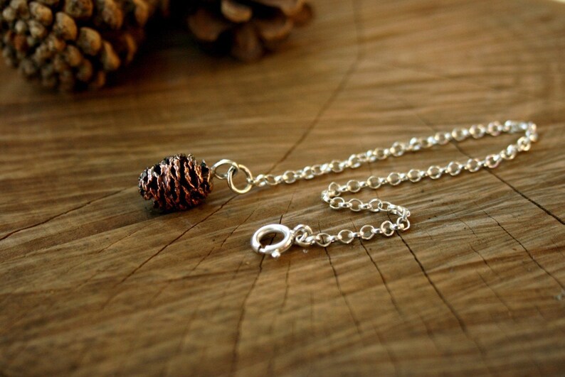 Handmade sterling silver chain bracelet with pink bronze pinecone charm. Each charm is crafted from a cast of an actual miniature cone. By Curious Magpie Jewellery.