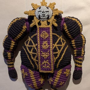 Close-up of Esquie amigurumi showing facial features, stitched outfit details, and embroidery. Crochet pattern PDF
