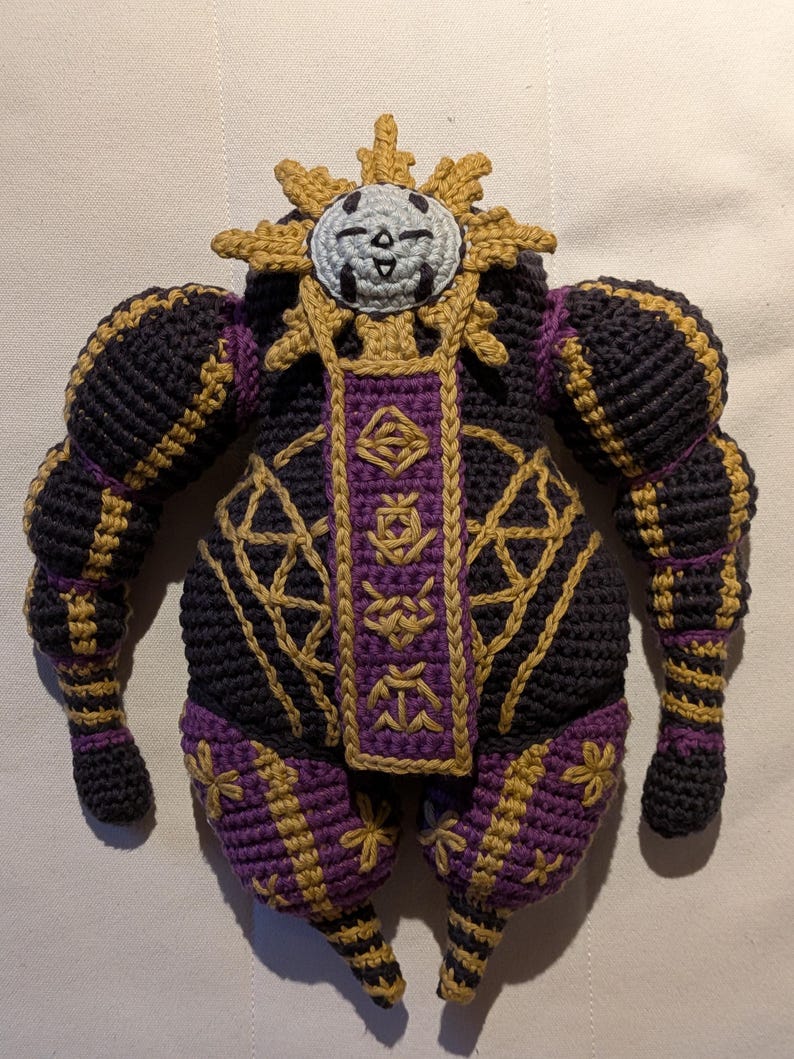 Close-up of Esquie amigurumi showing facial features, stitched outfit details, and embroidery. Crochet pattern PDF