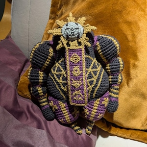 Finished Esquie crochet doll sitting upright, designed as a plush character from a fantasy game. Ideal for fans.