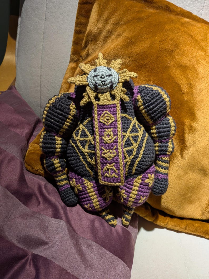 Finished Esquie crochet doll sitting upright, designed as a plush character from a fantasy game. Ideal for fans.