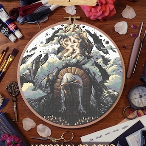Close-up of Paintress at the Monolith cross stitch, showing thread detail and DMC color blending in a 10-inch embroidery hoop