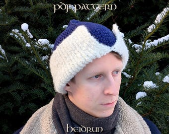 Könnte beinhalten: Nahaufnahme eines handgefertigten Winterhold-Hutmusters. Der Hut hat ein zweifarbiges Design in Weiß und Marineblau. Der Text "Winterhold hat pdf pattern" befindet sich oben im Bild. Der Markenname "heidrun crafts" steht unten.