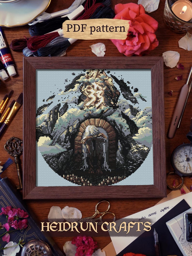 Finished cross stitch of the Paintress in silhouette against the towering monolith, with glowing highlights and dramatic framing.