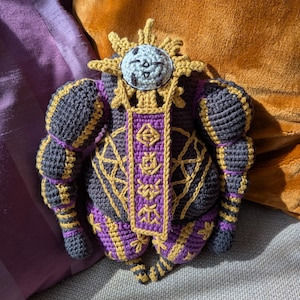 Finished Esquie crochet doll sitting upright, designed as a plush character from a fantasy game. Ideal for fans.