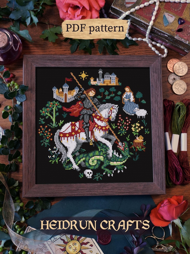 A cross-stitch pattern of St-Georges depicting the knight on horseback slaying a dragon. The pattern is set against a dark background with a medieval castle in the distance. The pattern is titled "PDF Pattern" and "Heidrun Crafts".