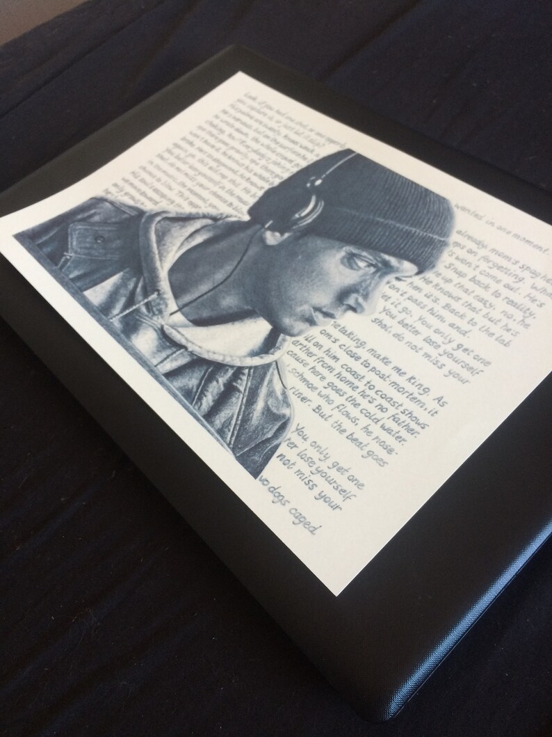 May include: A black and white illustration of a person wearing a black beanie and headphones. The image includes a quote: "retaking, make me king. As I'm close to post-mortem. It's either from home he's no father. On him coast to coast shows cause here goes the cold water. Schmoe who flows, he nose-riner. But the beat goes... You only get one, ter lose yourself, not miss your two dogs caged."