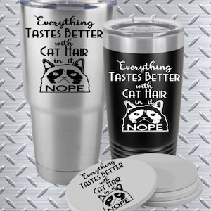 May include: Two stainless steel tumblers with a black and white image of a grumpy cat with the text "Everything Tastes Better with Cat Hair in it NOPE". A set of four white coasters with the same image and text.