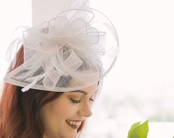May include: A woman wearing a white lace dress and a white lace hat holds a bouquet of pink and red flowers.