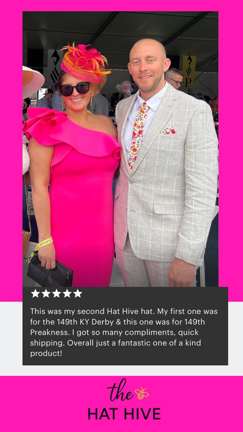 May include: A bright pink one-shoulder dress with a large ruffle detail paired with a matching pink and orange fascinator hat featuring netting. The ensemble is worn with black sunglasses and a black clutch, alongside a light grey plaid suit.