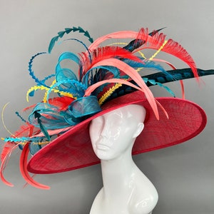 Red wide brim kentuck derby with teal bow and feathers.