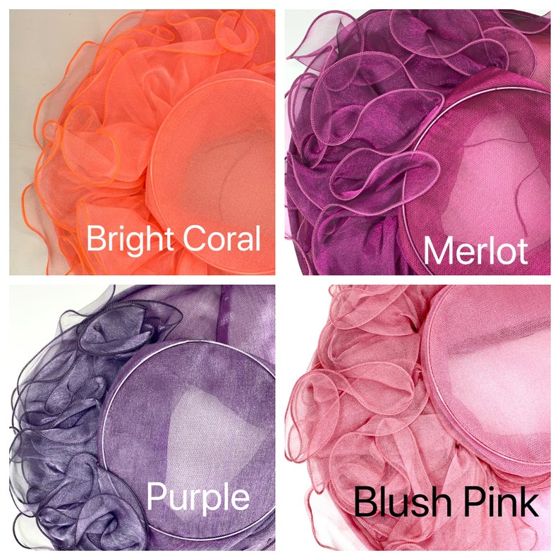 May include: Four different colored hats made of ruffled fabric. The hats are in the colors bright coral, merlot, purple, and blush pink.