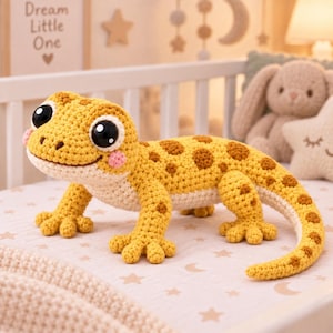 Peut inclure: Un gecko en peluche crocheté jaune et crème avec des taches brunes, de grands yeux noirs et des joues roses. Le lézard présente une surface en laine texturée, quatre pattes avec des orteils distincts et une longue queue courbée.