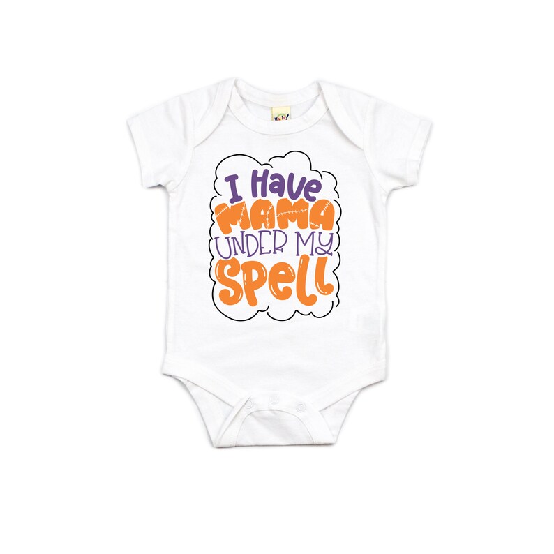 May include: White baby onesie with orange and purple text that reads "I have mama under my spell".